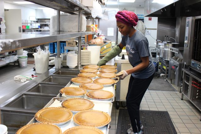 A Campus Kitchen volunteer prepares casseroles
